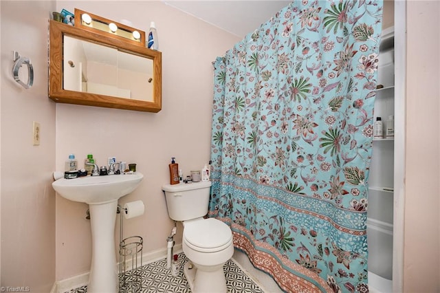 bathroom with a shower with curtain, sink, and toilet