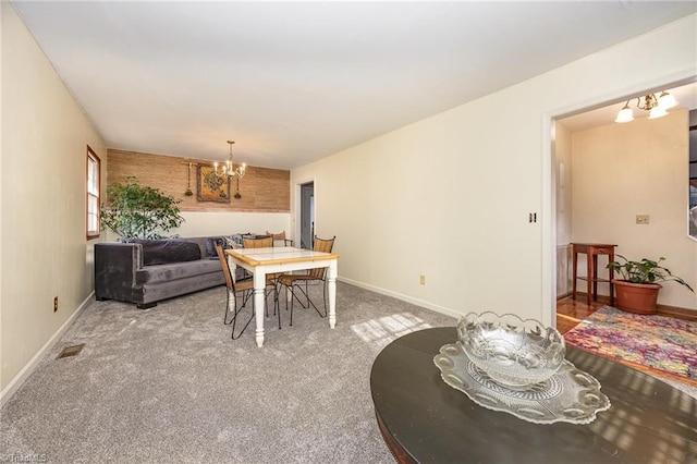 dining room with carpet flooring and an inviting chandelier