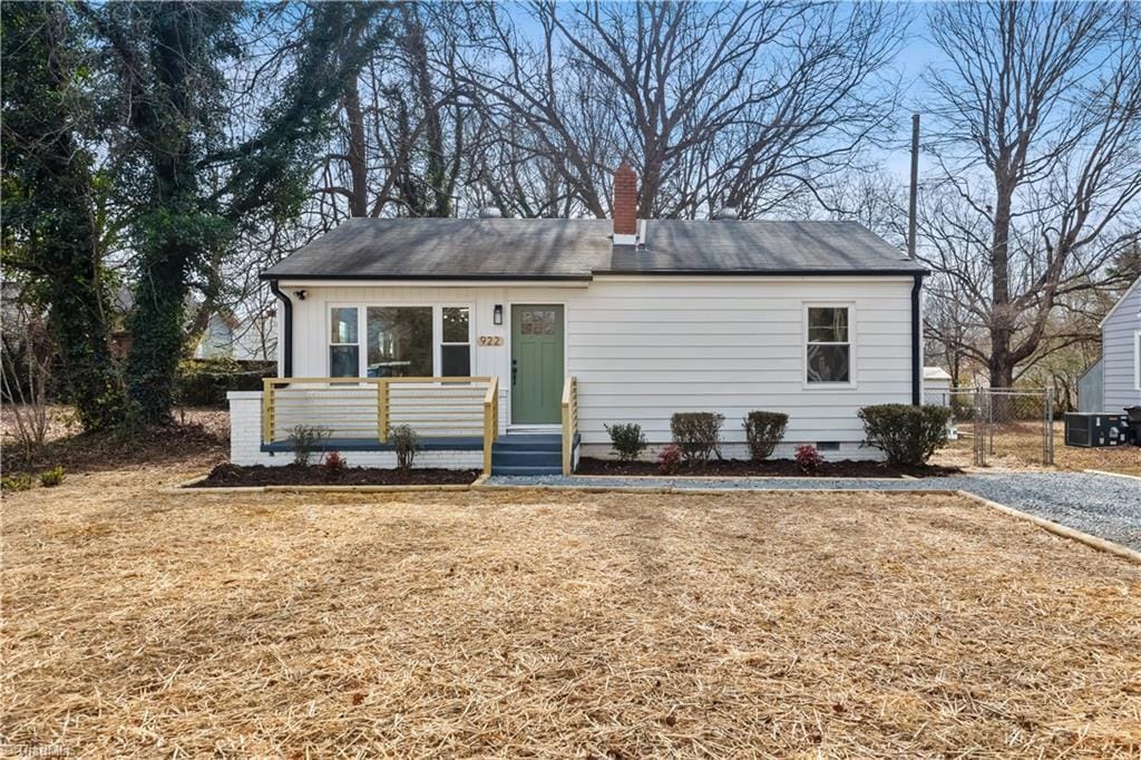 view of front of home featuring cooling unit and a front yard