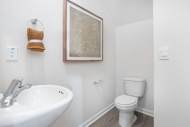 5504 Avery Dr, Trinity, NC 27370 - bathroom featuring a sink, wood finished floors, toilet, baseboards, and vaulted ceiling