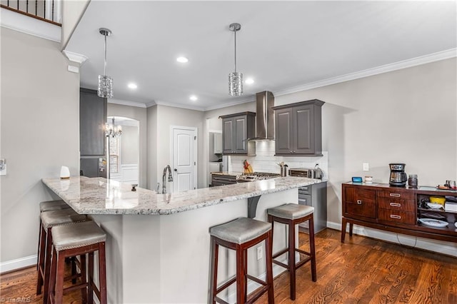 3632 Sally Kirk Rd, Winston-Salem, NC 27106 - kitchen featuring wall chimney exhaust hood, gray cabinets, a kitchen breakfast bar, ornamental molding, and recessed lighting