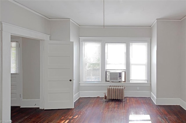 empty room with cooling unit, baseboards, ornamental molding, radiator, and dark wood-style floors