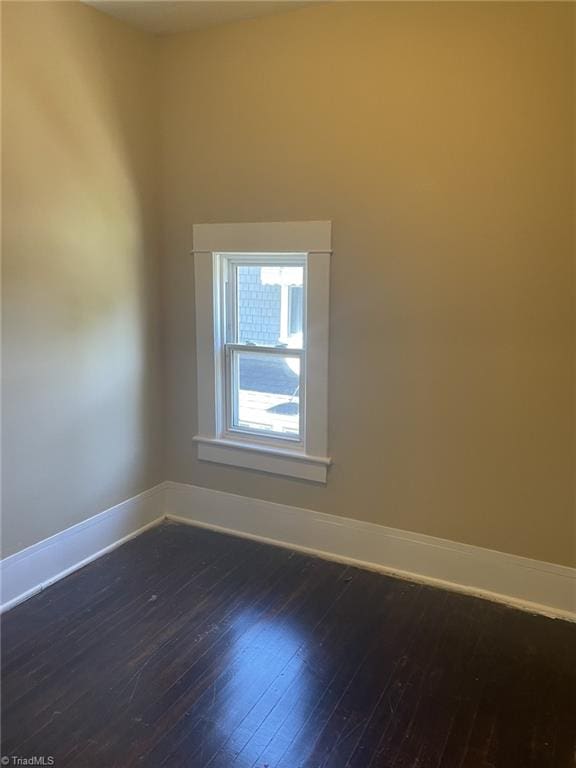 unfurnished room featuring wood-type flooring and baseboards