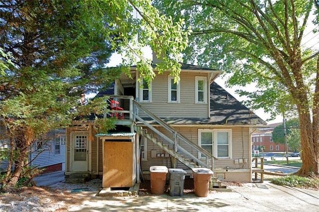 back of house featuring entry steps and stairway