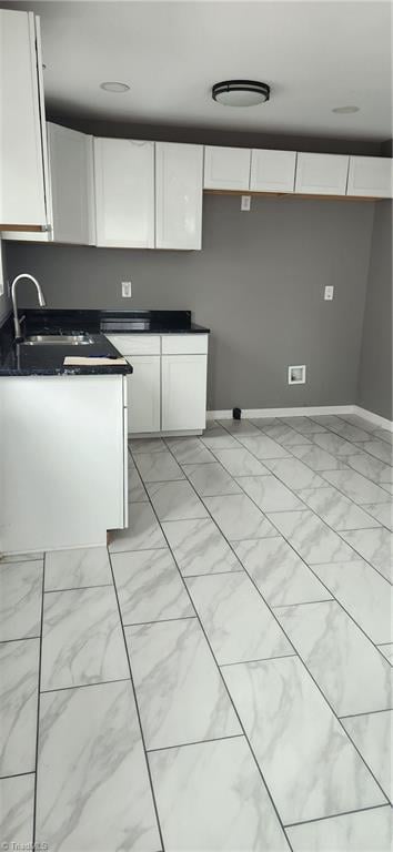 kitchen with white cabinetry and sink