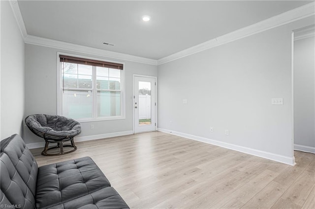 unfurnished living room with ornamental molding and light hardwood / wood-style floors