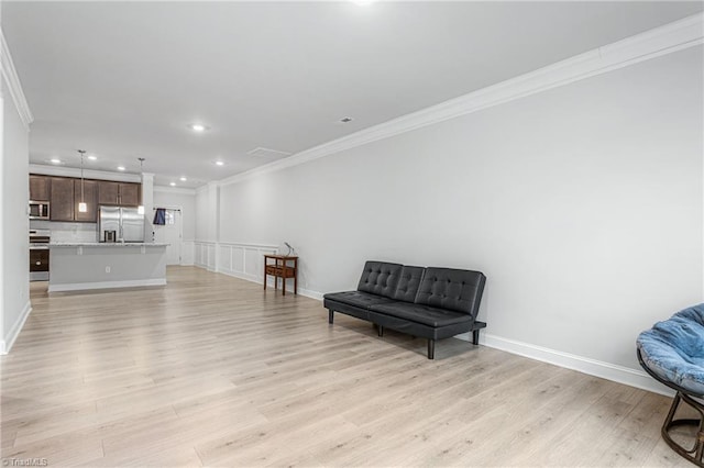 sitting room featuring ornamental molding and light hardwood / wood-style flooring