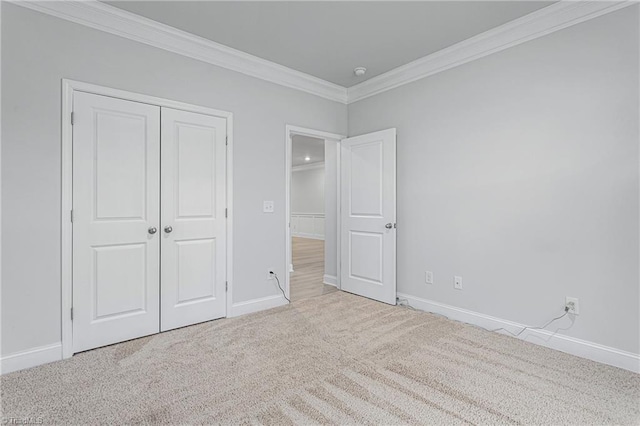 unfurnished bedroom featuring crown molding, light colored carpet, and a closet