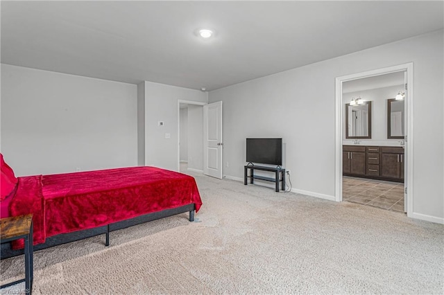 bedroom with ensuite bathroom, sink, and light carpet