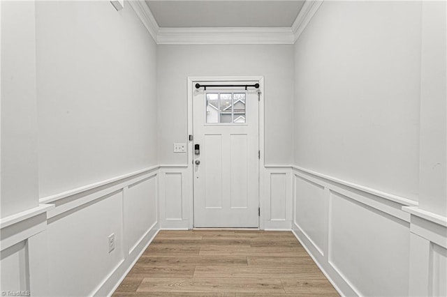 entryway with ornamental molding and light hardwood / wood-style floors