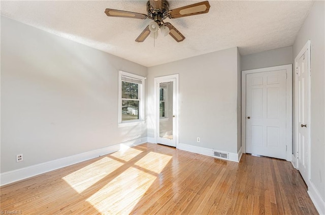 unfurnished bedroom with hardwood / wood-style floors, ceiling fan, and a textured ceiling