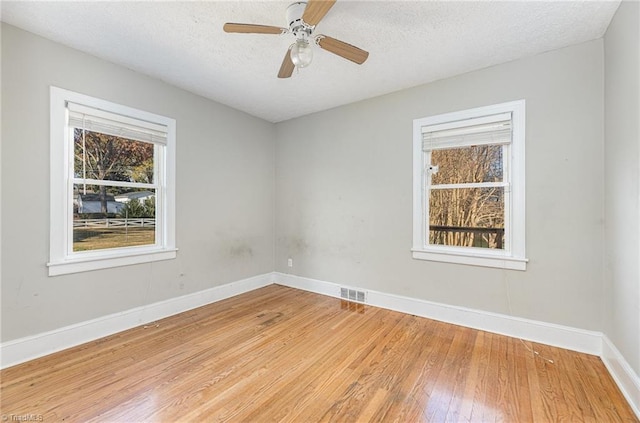 unfurnished room featuring hardwood / wood-style floors, ceiling fan, and a textured ceiling