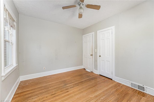 spare room featuring ceiling fan, light hardwood / wood-style floors, and a textured ceiling