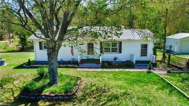 view of front of house with metal roof, a garage, and a front lawn