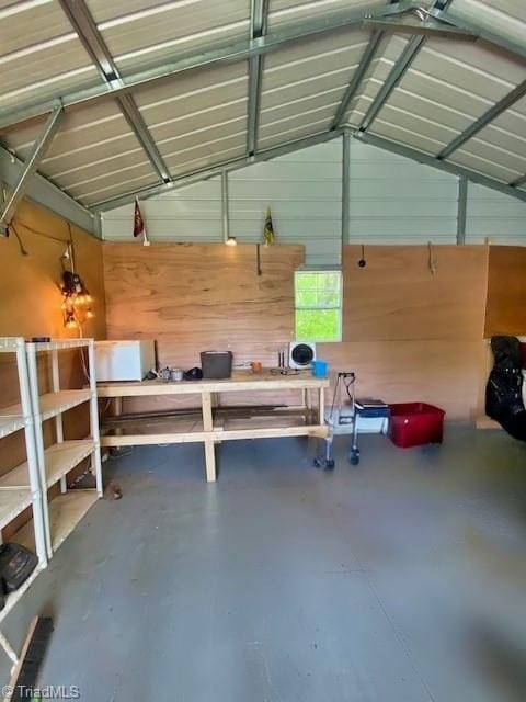 garage featuring wood walls and a workshop area