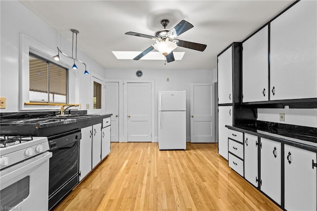 kitchen with white appliances, light hardwood / wood-style floors, white cabinets, a skylight, and ceiling fan