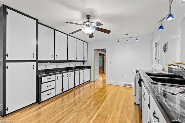 kitchen with white cabinets, ceiling fan, sink, and light wood-type flooring