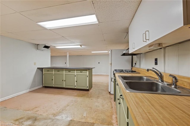 kitchen with green cabinetry, a paneled ceiling, sink, and stainless steel range with gas cooktop