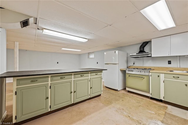 kitchen with green cabinetry, exhaust hood, sink, and white appliances