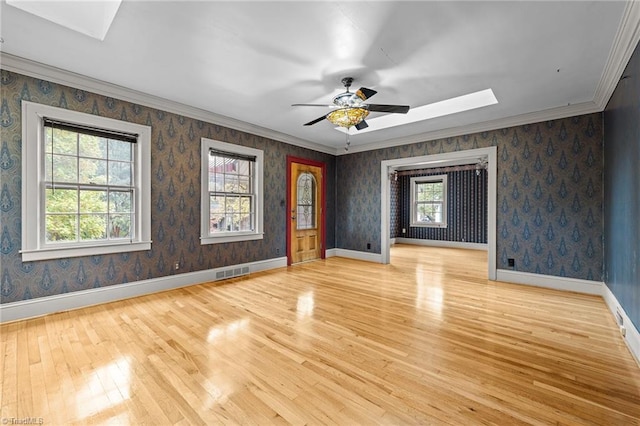 unfurnished room featuring light wood-type flooring, a healthy amount of sunlight, and ceiling fan