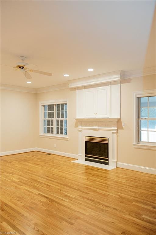 unfurnished living room with light hardwood / wood-style flooring, ceiling fan, and ornamental molding