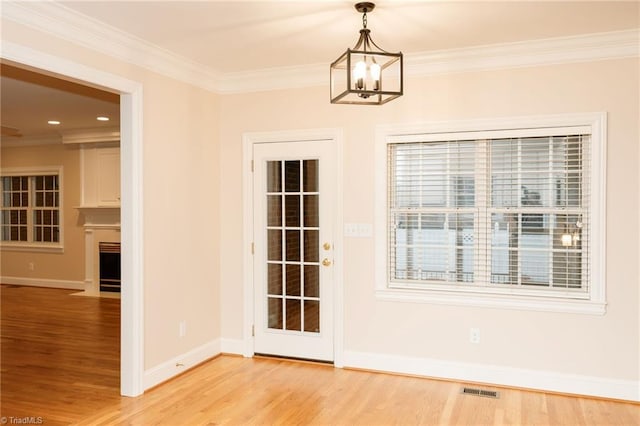 unfurnished dining area with a chandelier, crown molding, and wood-type flooring