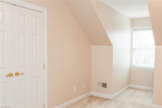 bonus room with light carpet and lofted ceiling