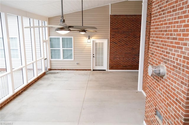 unfurnished sunroom featuring ceiling fan and vaulted ceiling