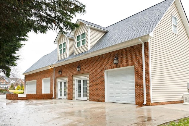 view of property exterior featuring a garage and french doors