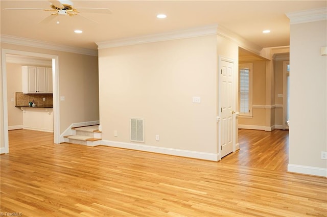 spare room featuring ceiling fan, ornamental molding, and light hardwood / wood-style flooring