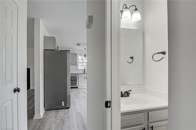 bathroom featuring wine cooler, vanity, and hardwood / wood-style flooring