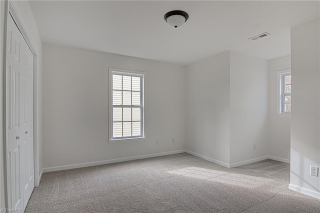 unfurnished bedroom featuring light colored carpet and a closet