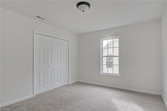 unfurnished bedroom featuring carpet and a closet