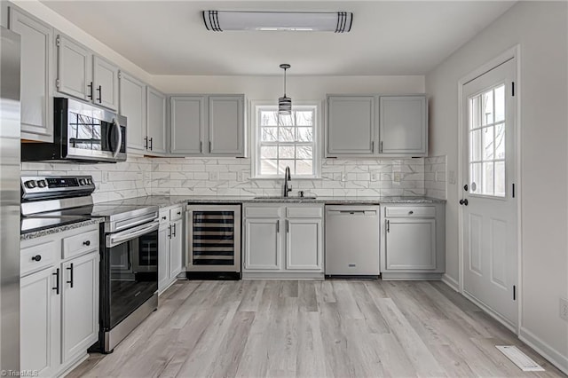 kitchen featuring wine cooler, a wealth of natural light, sink, and appliances with stainless steel finishes