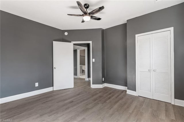 unfurnished bedroom with a closet, wood-type flooring, and ceiling fan