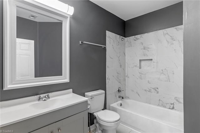 full bathroom with tiled shower / bath, vanity, and toilet