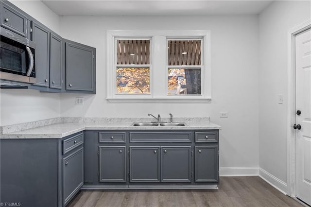 kitchen with dark hardwood / wood-style flooring, sink, and gray cabinets