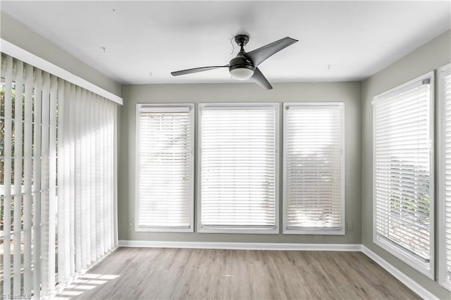 unfurnished sunroom featuring ceiling fan