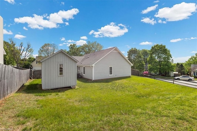 back of property featuring an outdoor structure, a yard, fence private yard, and board and batten siding