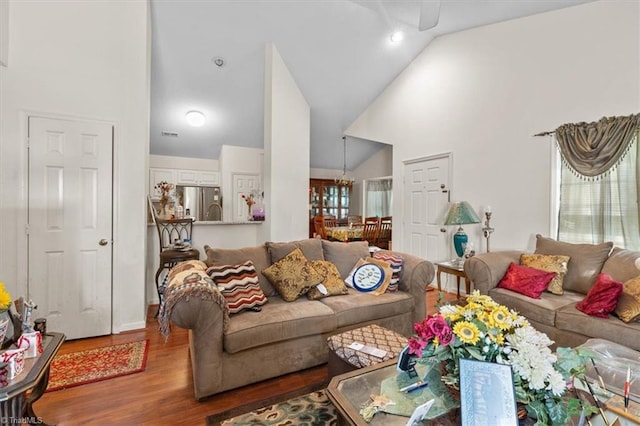 living room featuring high vaulted ceiling, wood finished floors, an inviting chandelier, and recessed lighting