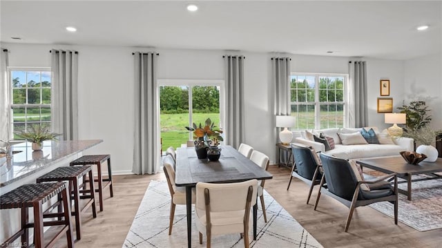 dining area with plenty of natural light and light hardwood / wood-style flooring