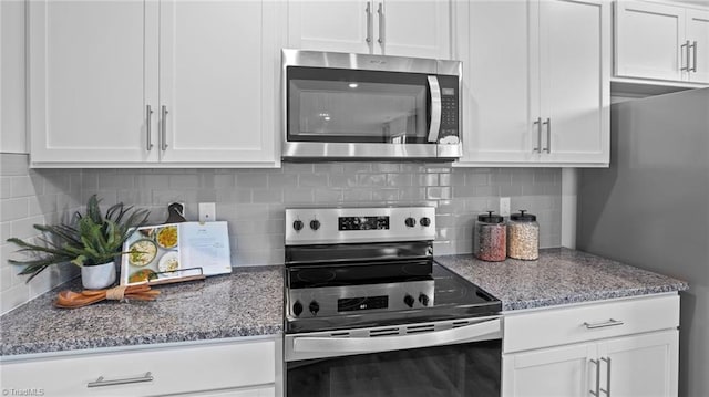 kitchen with decorative backsplash, appliances with stainless steel finishes, white cabinetry, and light stone counters