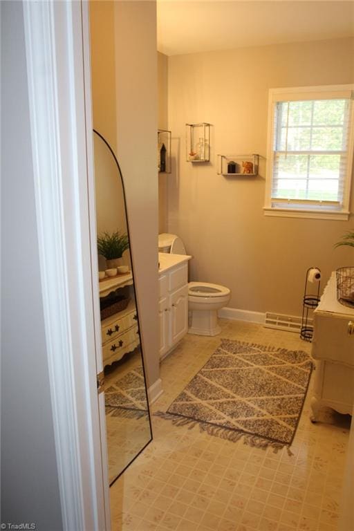 bathroom with tile patterned flooring, vanity, and toilet