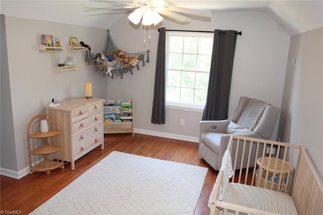 living area with lofted ceiling, ceiling fan, and dark wood-type flooring