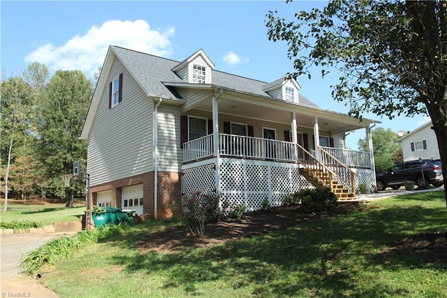 view of front of property with a porch, a front lawn, and a garage