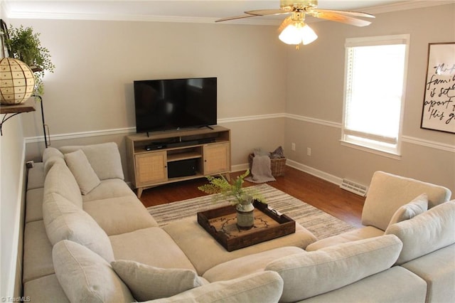 living room featuring ceiling fan, ornamental molding, and wood-type flooring