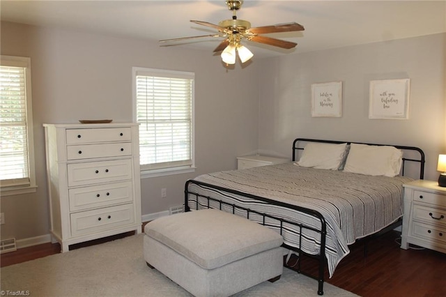 bedroom with ceiling fan, light hardwood / wood-style floors, and multiple windows