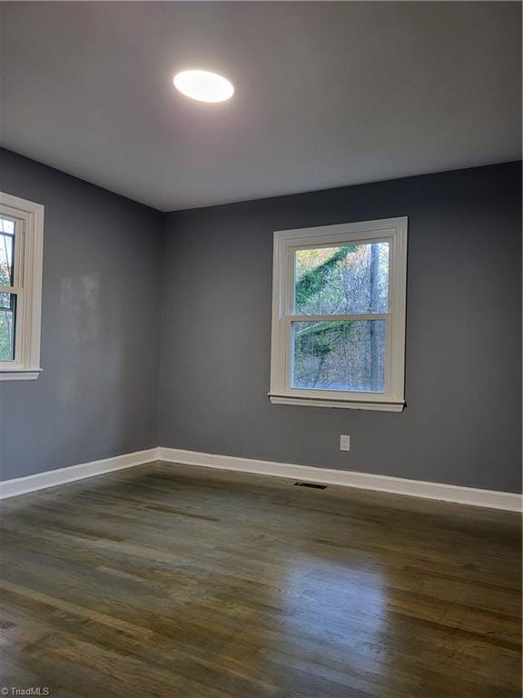 empty room with dark hardwood / wood-style floors