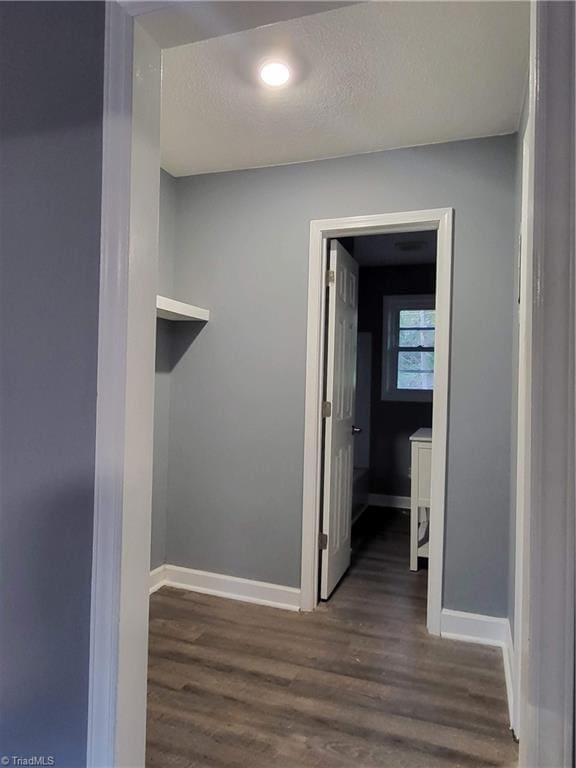 hallway featuring dark hardwood / wood-style flooring and a textured ceiling