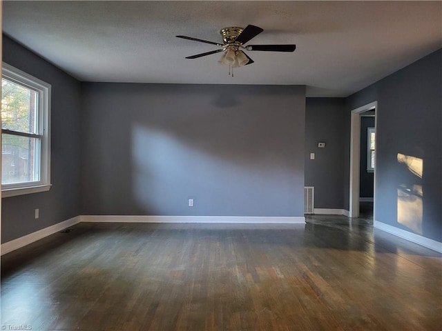 empty room featuring ceiling fan and dark hardwood / wood-style flooring